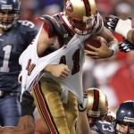 A pair of Seattle Seahawks pull down San Francisco quarterback Alex Smith (11) by the threads of his jersey Nov. 12, 2007 during a NFL football game at Qwest Field in Seattle, Wash. The arm of Seahawks linebacker Julian Peterson (59) is at left and the arm of defensive tackle Craig Terrill (93) is at right.