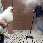 Scott Swartz, 14, steam cleans his family’s deck that gets messy each week because of his pet rooster Rooroo, held by his sister Christy, 13, April 12, 2005 in Camano Island, Wash.  Cleaning the deck is one of many chores that Swartz does every week to get $10 worth of quarters to operate his video game system.  Swartz gets 11 minutes for each quarter.